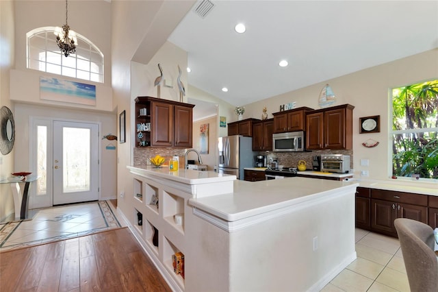 kitchen featuring an inviting chandelier, tasteful backsplash, stainless steel appliances, and light tile floors