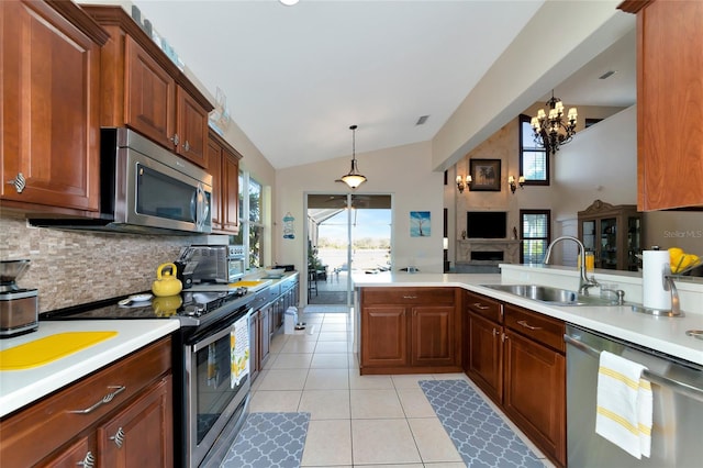 kitchen with plenty of natural light, pendant lighting, stainless steel appliances, and an inviting chandelier