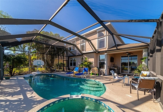 view of pool with an outdoor hot tub, a patio, ceiling fan, and glass enclosure