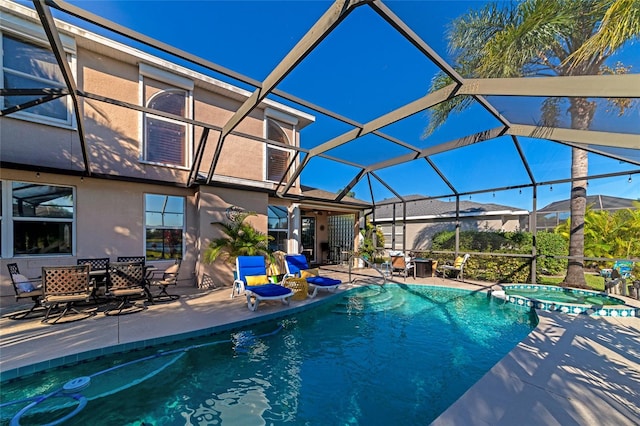 view of swimming pool featuring an in ground hot tub, glass enclosure, and a patio