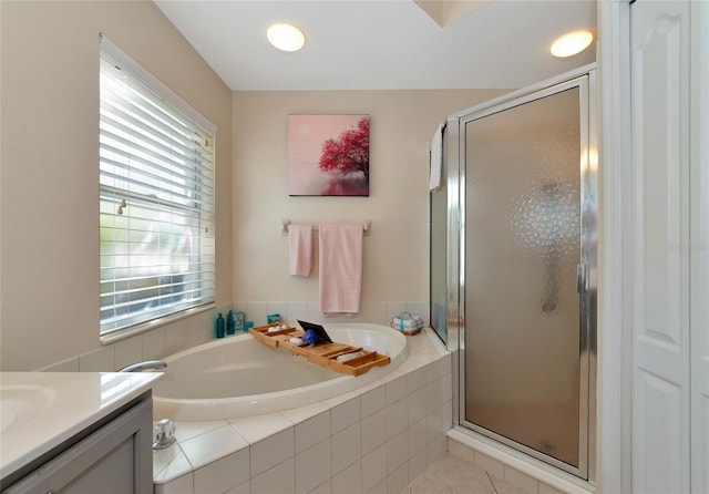 bathroom featuring tile floors, separate shower and tub, and vanity