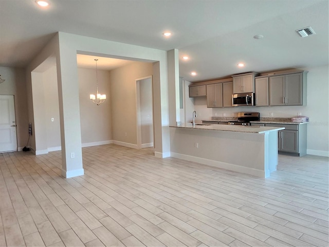 kitchen with pendant lighting, an inviting chandelier, gray cabinets, appliances with stainless steel finishes, and kitchen peninsula