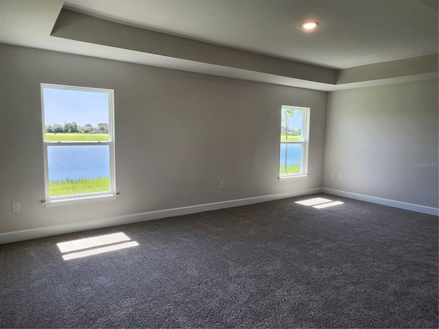 carpeted spare room featuring a water view