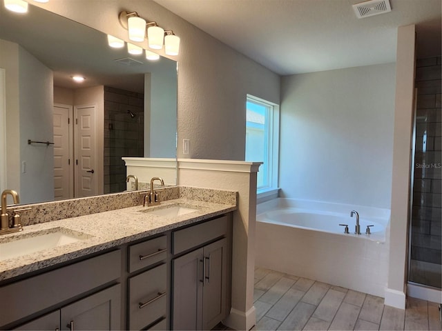 bathroom featuring vanity and shower with separate bathtub