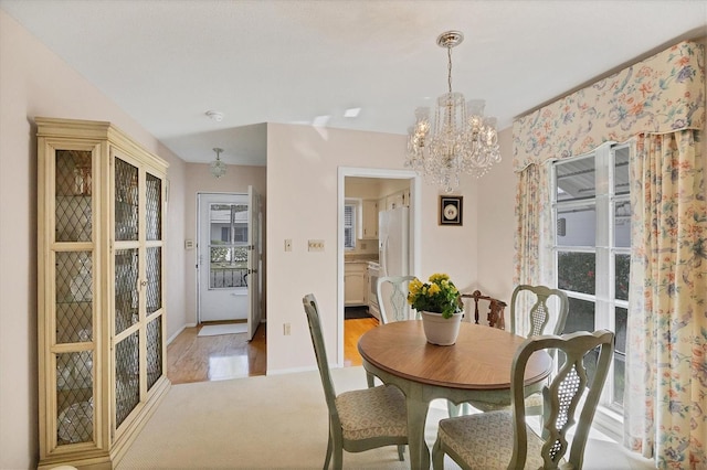 dining space with a notable chandelier, carpet floors, and a wealth of natural light