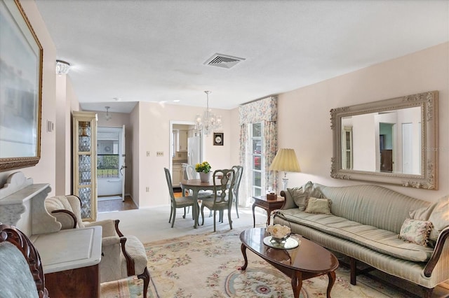 carpeted living room with a textured ceiling and an inviting chandelier