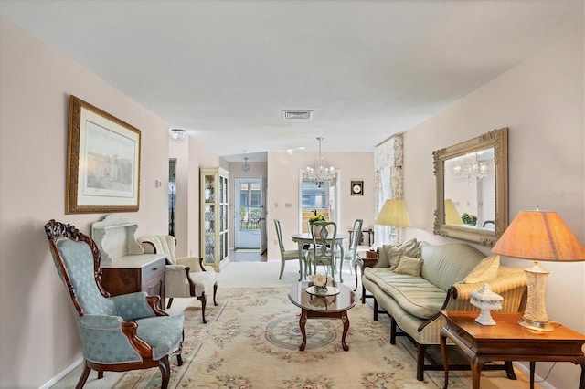 living area with light colored carpet and an inviting chandelier