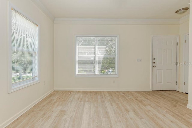 empty room with crown molding and light hardwood / wood-style flooring