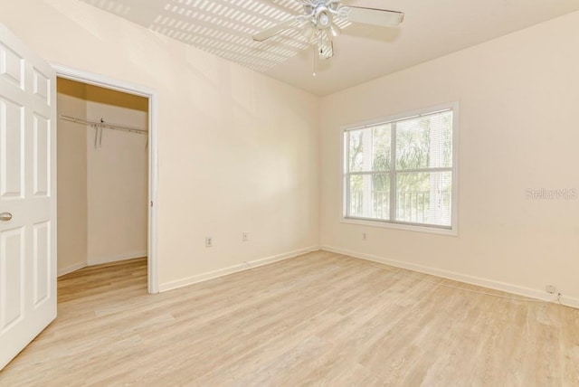 unfurnished bedroom with ceiling fan, light wood-type flooring, and a closet