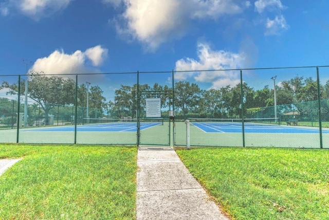 view of sport court with a lawn