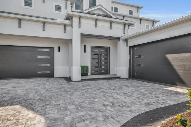 view of exterior entry featuring french doors and a garage