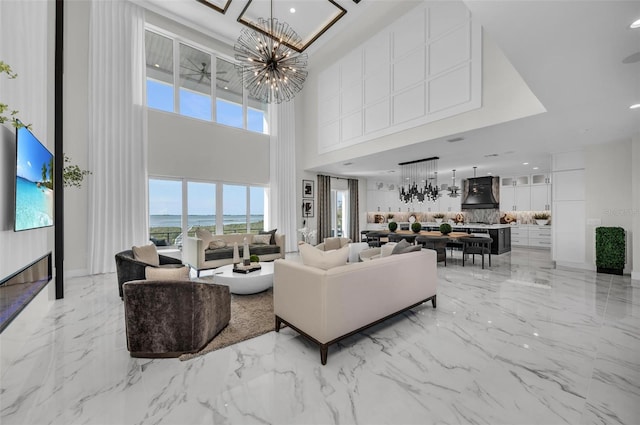 tiled living room featuring a high ceiling and an inviting chandelier