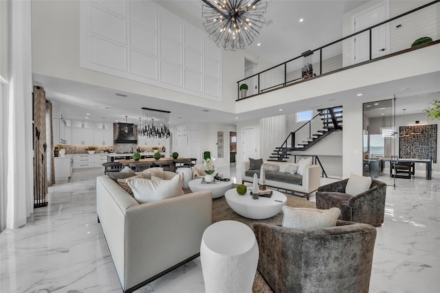 living room with a notable chandelier, a towering ceiling, and light tile flooring