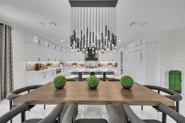 dining room featuring a chandelier, light tile floors, and sink