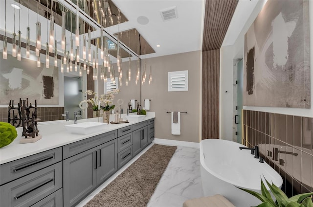 bathroom featuring double sink vanity, a washtub, tile floors, and a notable chandelier