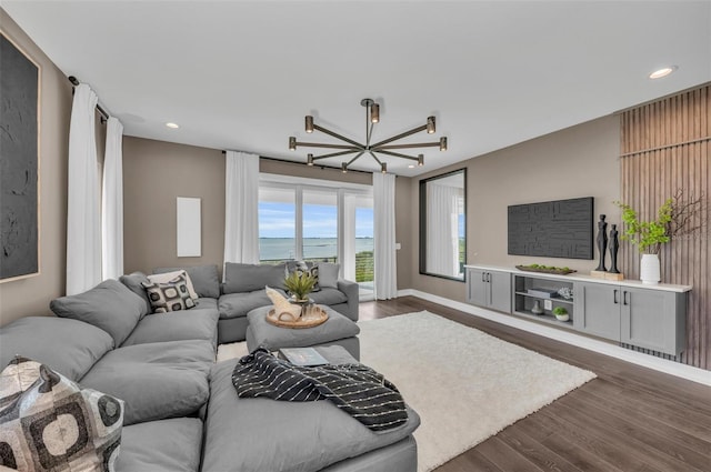 living room featuring a water view, an inviting chandelier, and dark hardwood / wood-style flooring