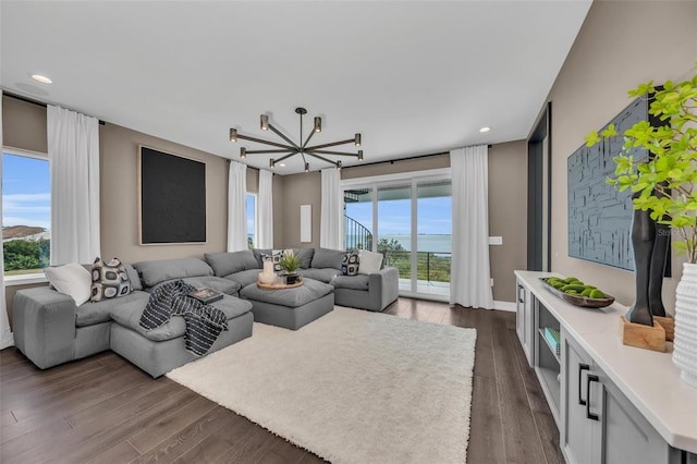 living room with a chandelier and dark wood-type flooring