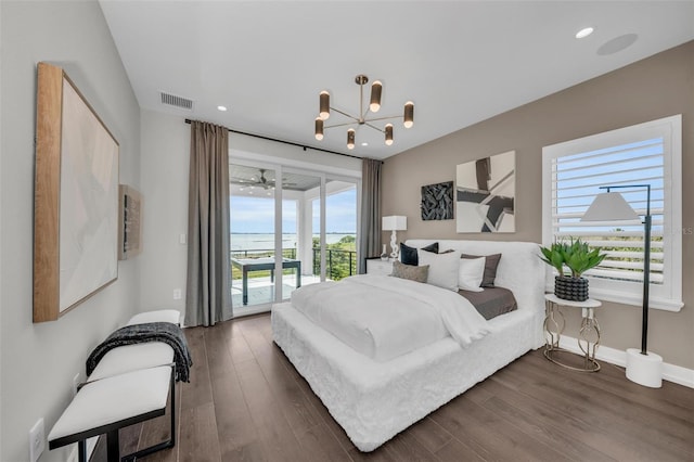 bedroom with an inviting chandelier, dark wood-type flooring, and access to exterior