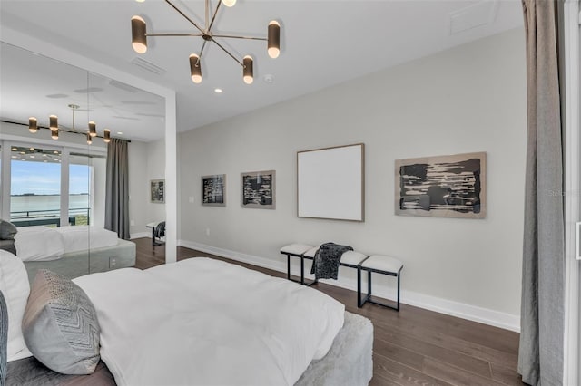 bedroom featuring an inviting chandelier and dark wood-type flooring