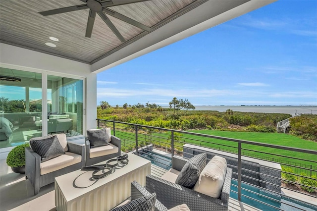 balcony with outdoor lounge area, ceiling fan, and a water view