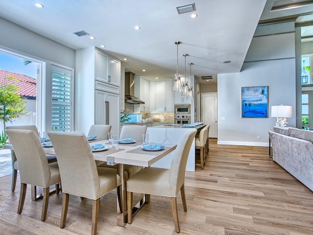 dining space with a wealth of natural light and light wood-type flooring