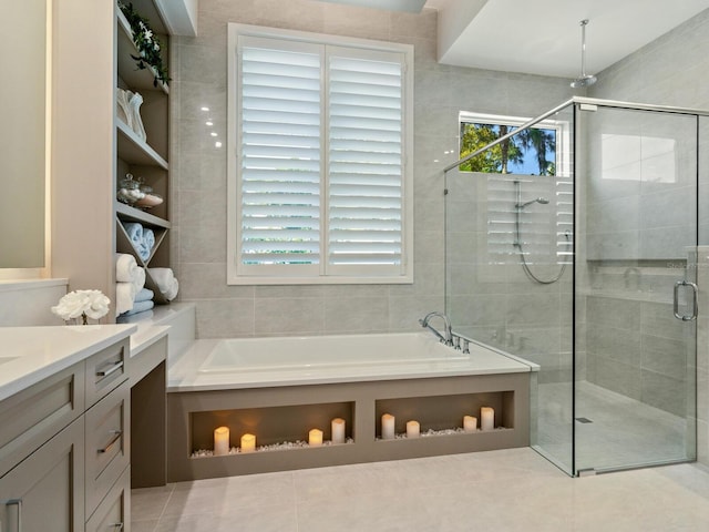 bathroom featuring independent shower and bath, tile floors, and vanity