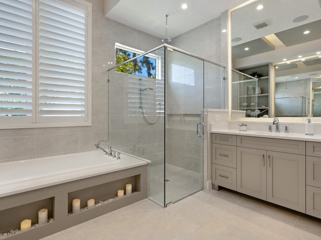 bathroom with shower with separate bathtub, tile flooring, and vanity