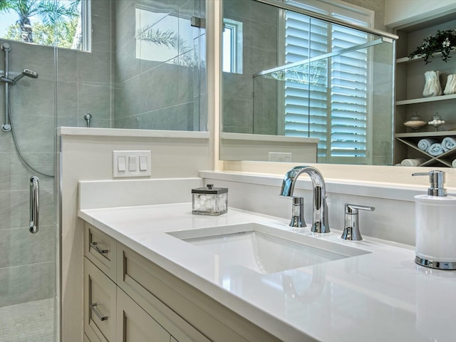 bathroom with a healthy amount of sunlight, vanity with extensive cabinet space, and an enclosed shower