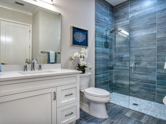 bathroom featuring walk in shower, toilet, and vanity with extensive cabinet space