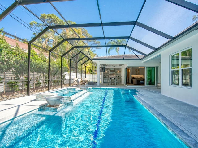 view of swimming pool with a patio area, an in ground hot tub, a lanai, and pool water feature