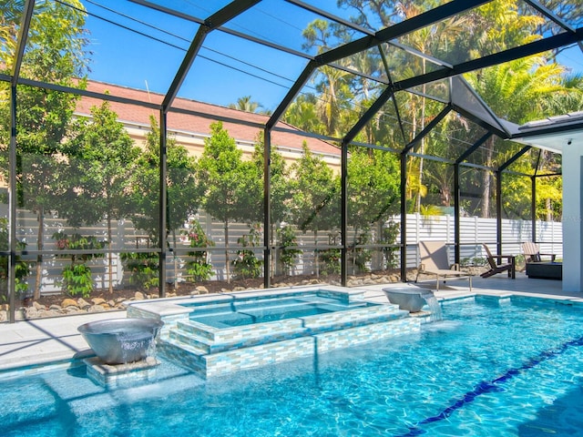 view of swimming pool with an in ground hot tub, pool water feature, glass enclosure, and a patio