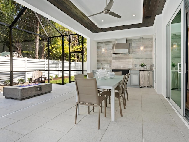 sunroom featuring a tray ceiling and ceiling fan