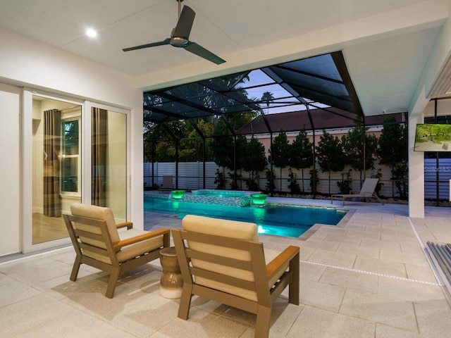 pool at dusk with ceiling fan and a patio