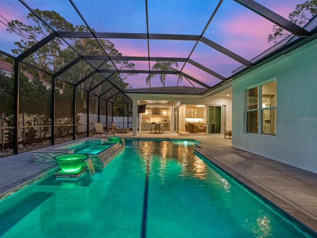 pool at dusk featuring a patio area and glass enclosure