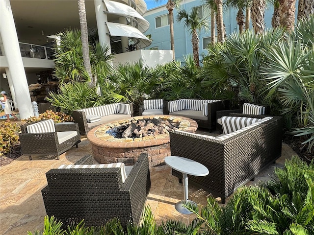 view of patio featuring a balcony and an outdoor living space with a fire pit