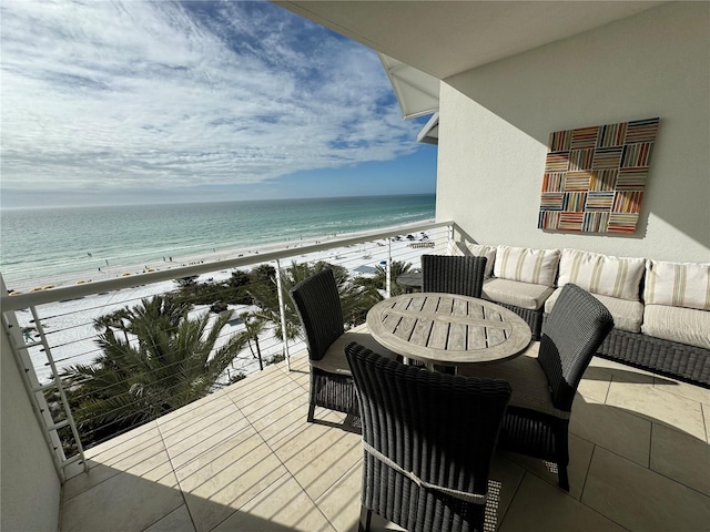 balcony with a water view and a view of the beach