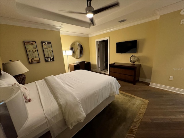 bedroom featuring ceiling fan, a raised ceiling, dark hardwood / wood-style flooring, and ornamental molding