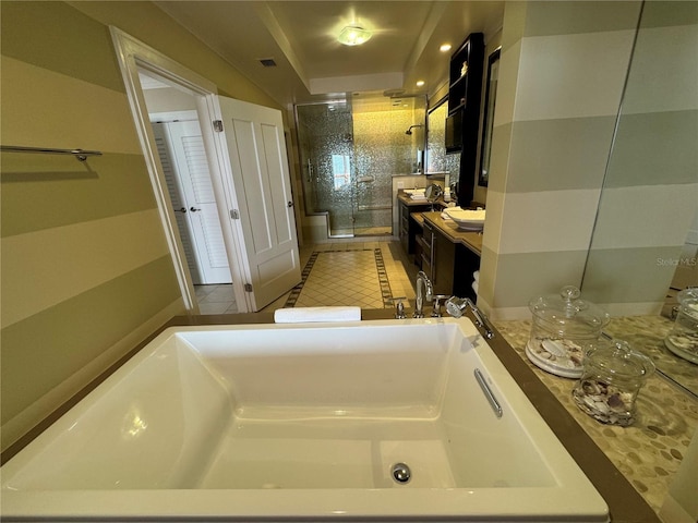 bathroom with a washtub, tile floors, and vanity