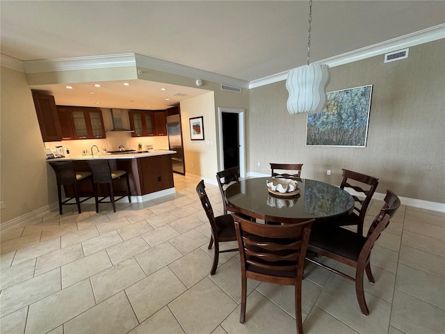 tiled dining area featuring ornamental molding