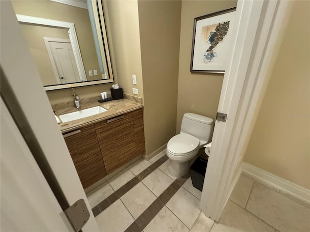 bathroom with toilet, vanity, and tile flooring