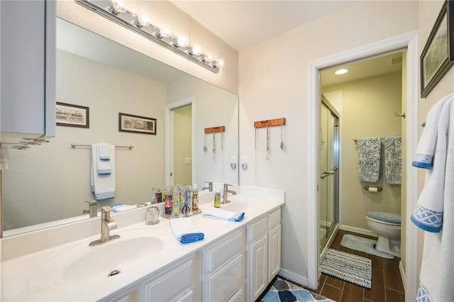 bathroom featuring vanity, hardwood / wood-style floors, an enclosed shower, and toilet