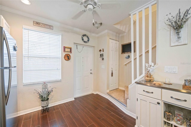 foyer with ceiling fan, ornamental molding, and dark wood-type flooring