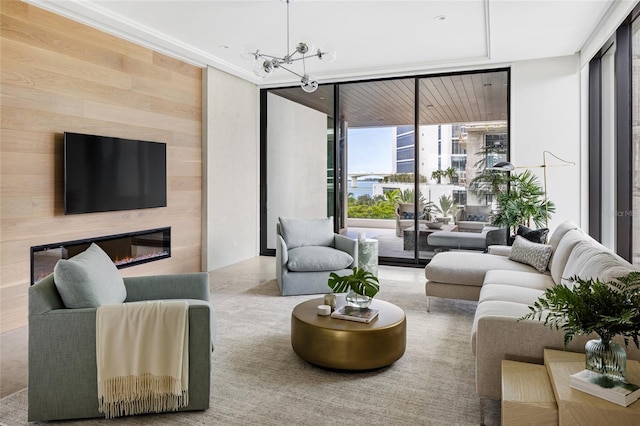 living room with an inviting chandelier, a wall of windows, and wood walls