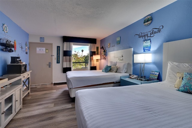 bedroom featuring dark hardwood / wood-style flooring and a textured ceiling