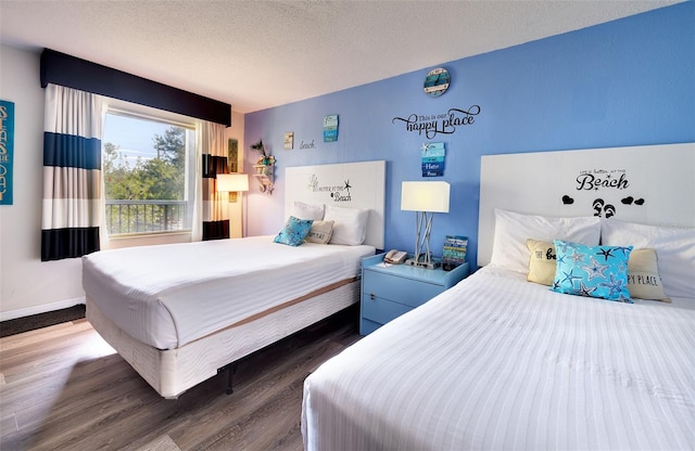 bedroom featuring a textured ceiling and dark hardwood / wood-style floors