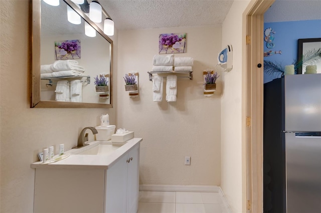 bathroom featuring vanity with extensive cabinet space, tile flooring, and a textured ceiling