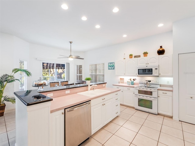 kitchen featuring ceiling fan, white appliances, sink, a center island with sink, and white cabinets