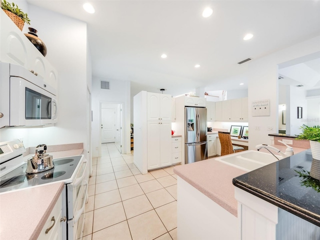 kitchen featuring white appliances, light tile flooring, white cabinetry, and sink