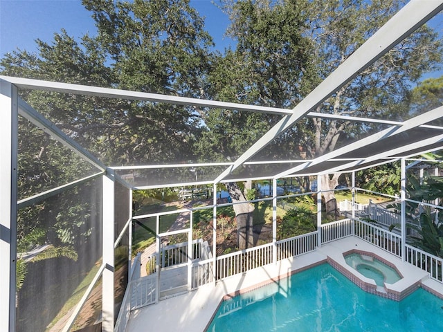 view of swimming pool with an in ground hot tub and glass enclosure