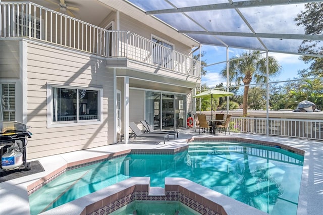 view of swimming pool featuring an in ground hot tub, a patio, and a lanai